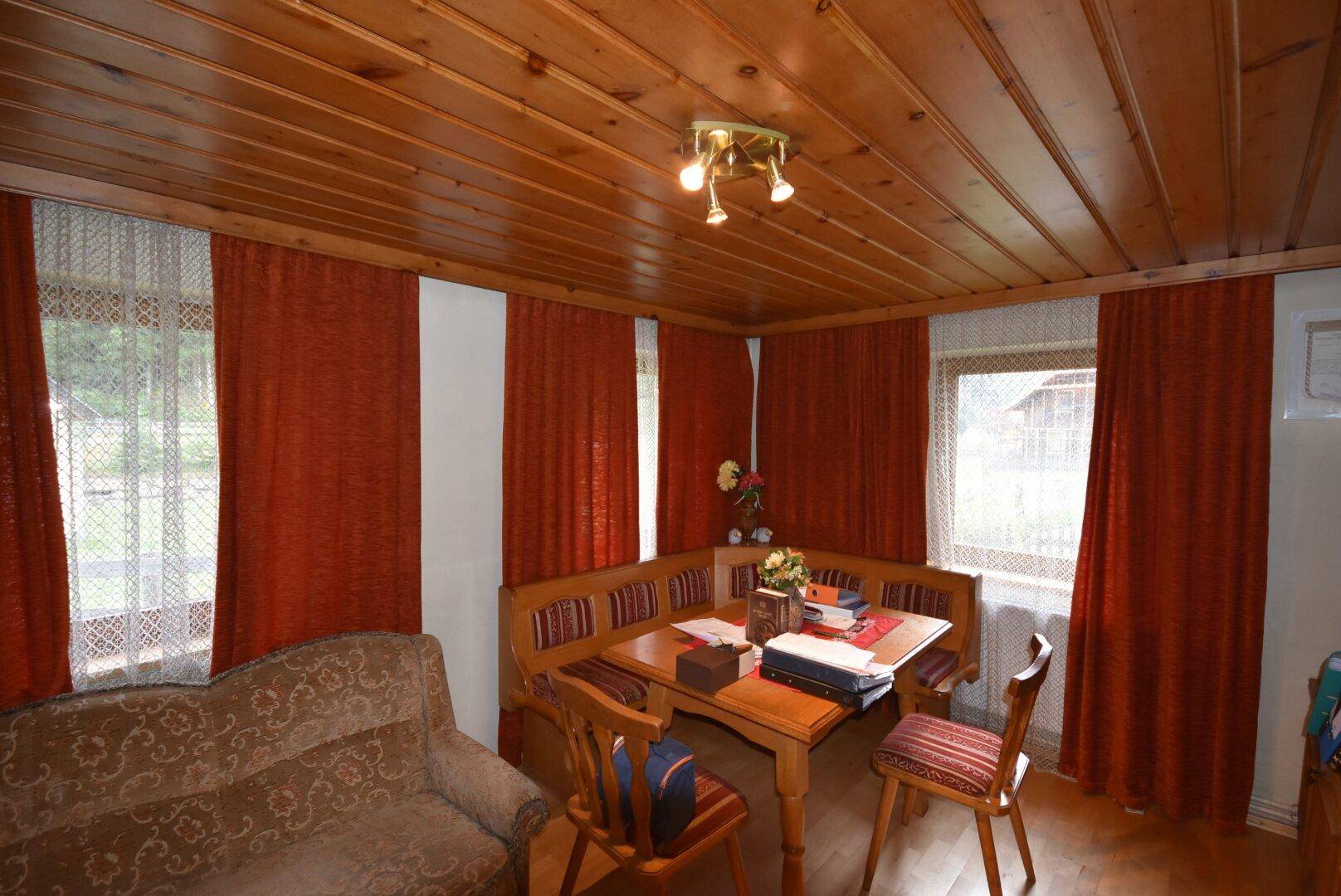 Gemütlicher Wohn-Essbereich mit Holztäfelung, Eckbank und traditioneller Einrichtung.