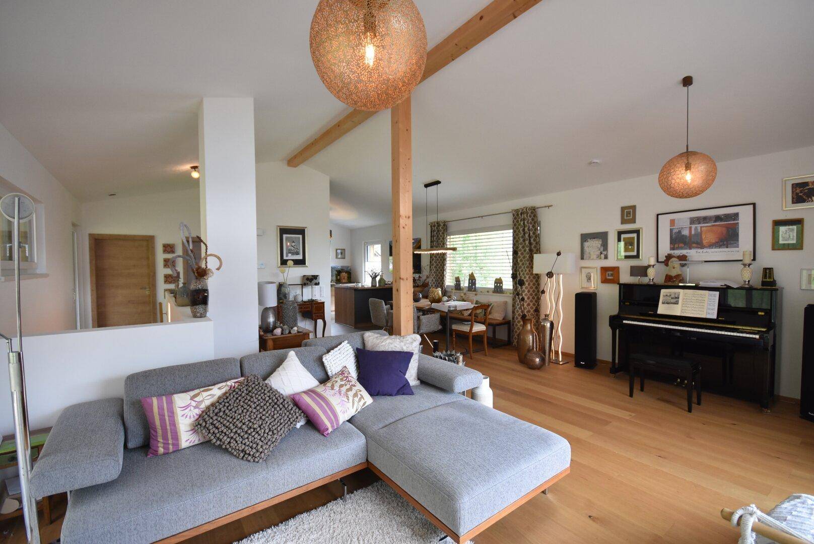 Geräumiger Wohnbereich mit bequemer Couch, Holzboden und dekorativen Leuchten.