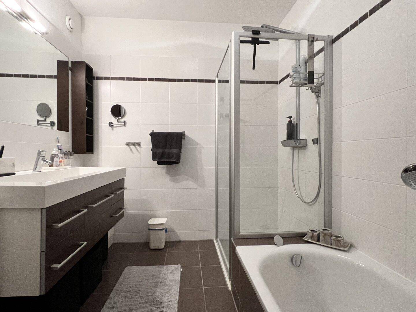 Modernes Badezimmer mit Badewanne, Duschkabine und großem Waschtisch.