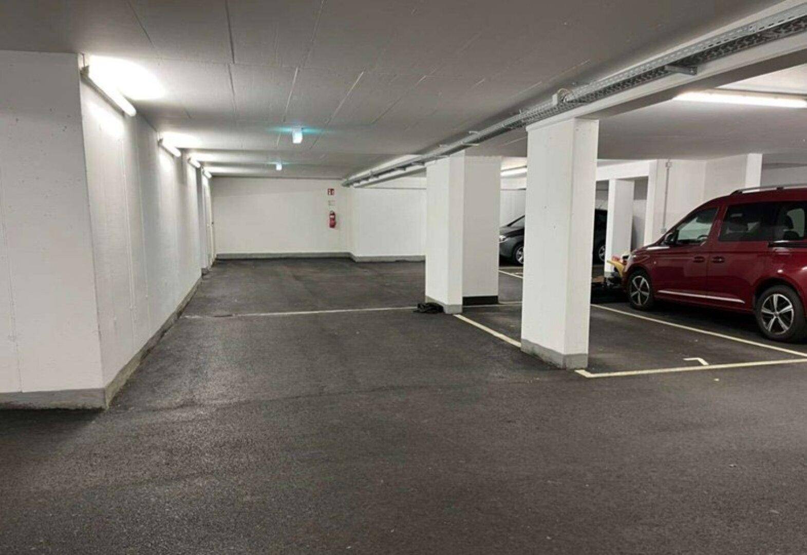 Helle Tiefgarage mit markierten Stellplätzen und ausreichend Platz für Fahrzeuge.