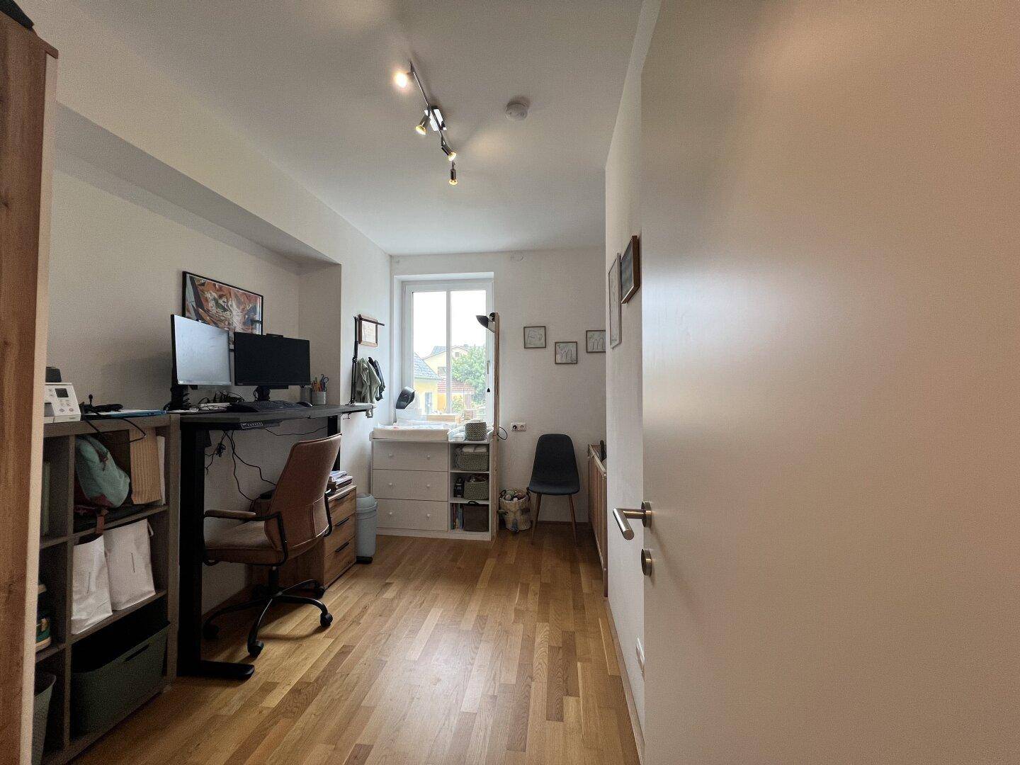 Funktionales Arbeitszimmer mit Schreibtisch, Regalen und einem Fenster, ideal für Home-Office.