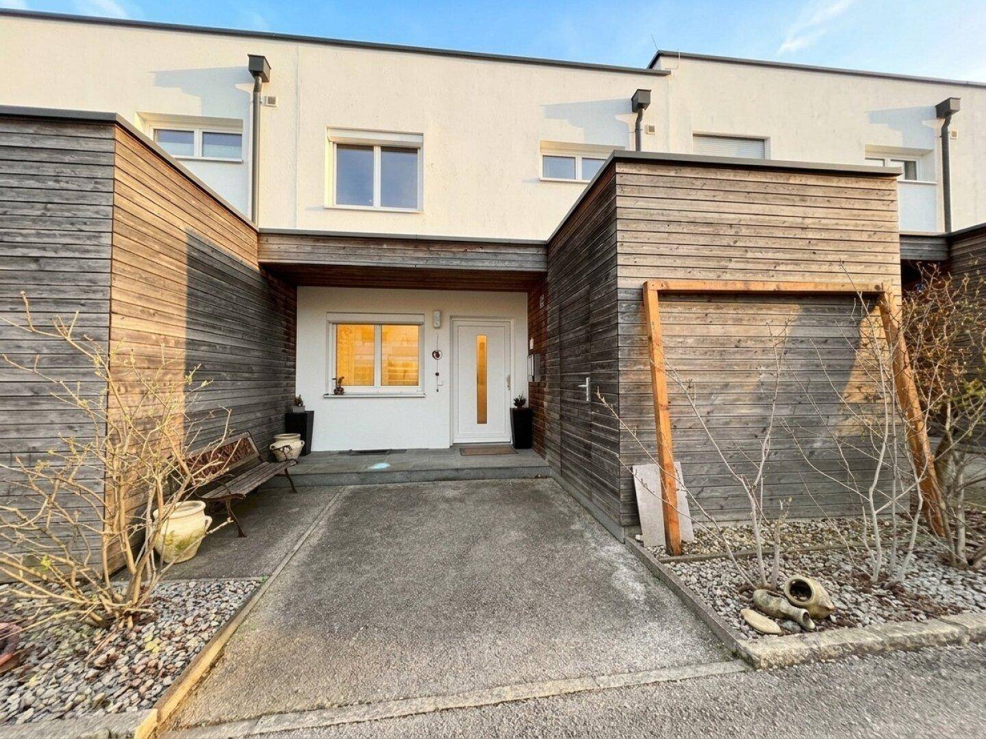 Eingangsbereich eines modernen Reihenhauses mit Holzverkleidung und schlichtem Design.