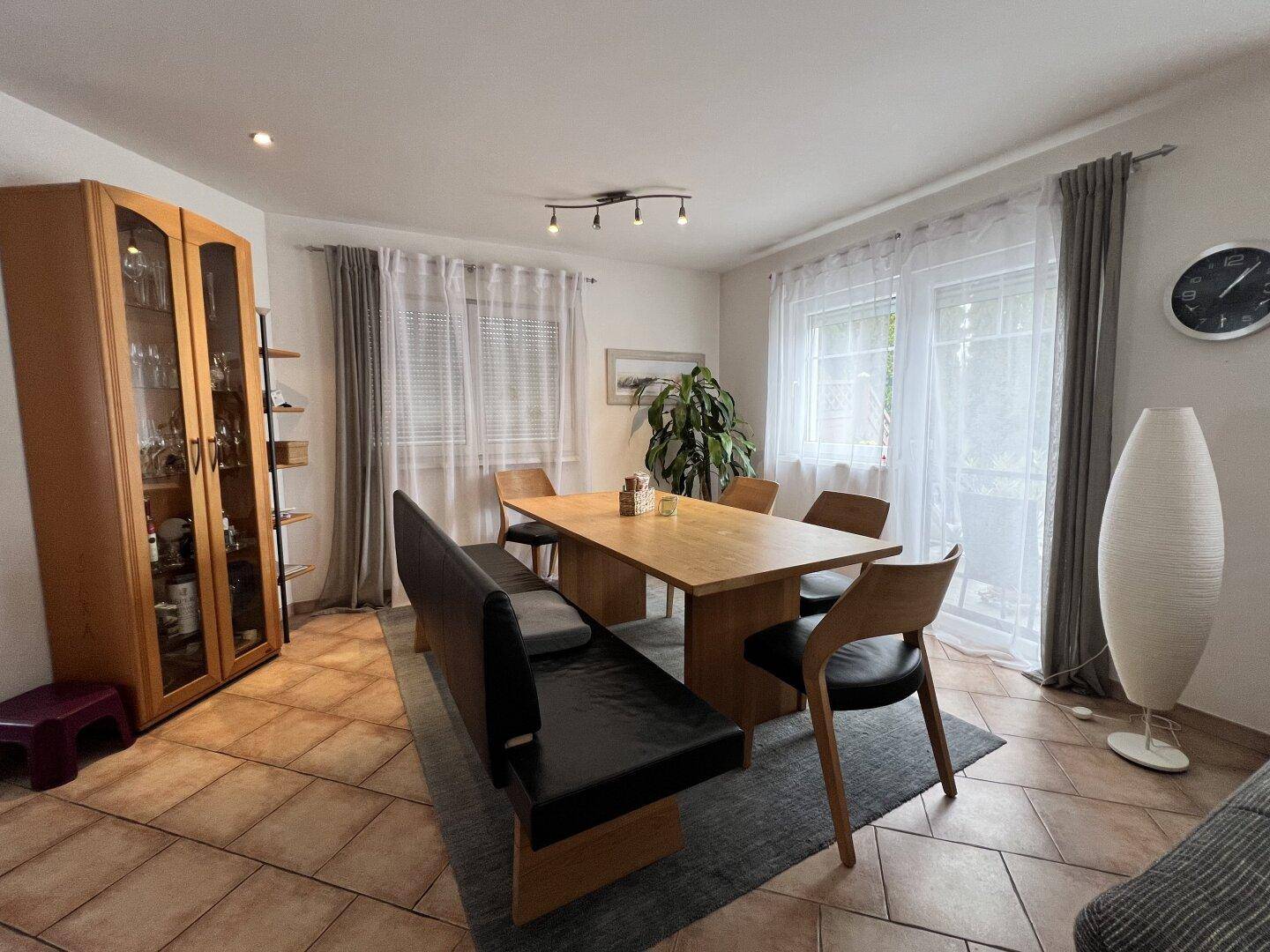 Heller Essbereich mit Holztisch, Sitzbank und Terrakottafliesen, ideal für Familienessen.