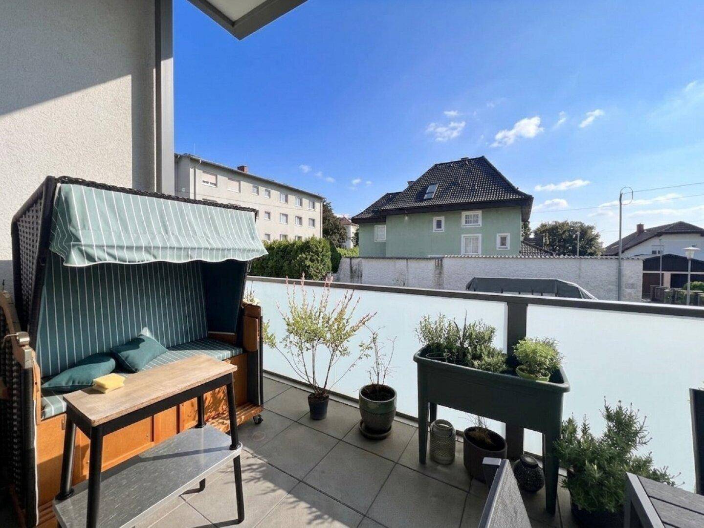 Gemütlicher Balkon mit Strandkorb und Pflanzen, perfekt zum Entspannen und Genießen der frischen Luft.