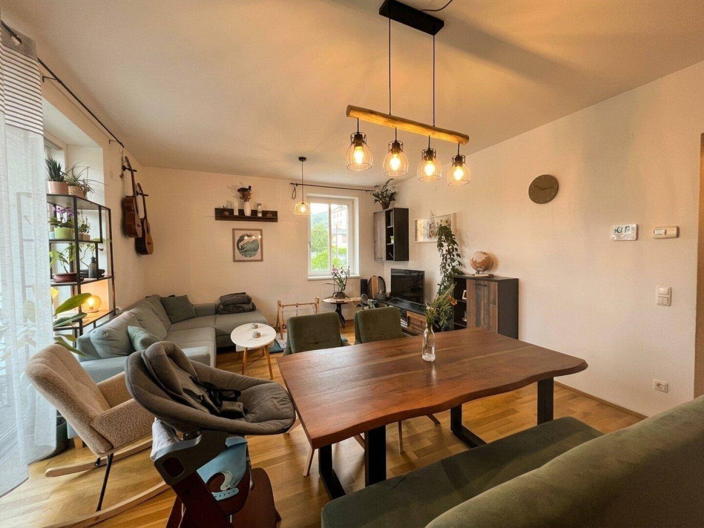 Geräumiger Wohn-Essbereich mit Holzboden, großem Esstisch und bequemer Sitzecke für gesellige Stunden.