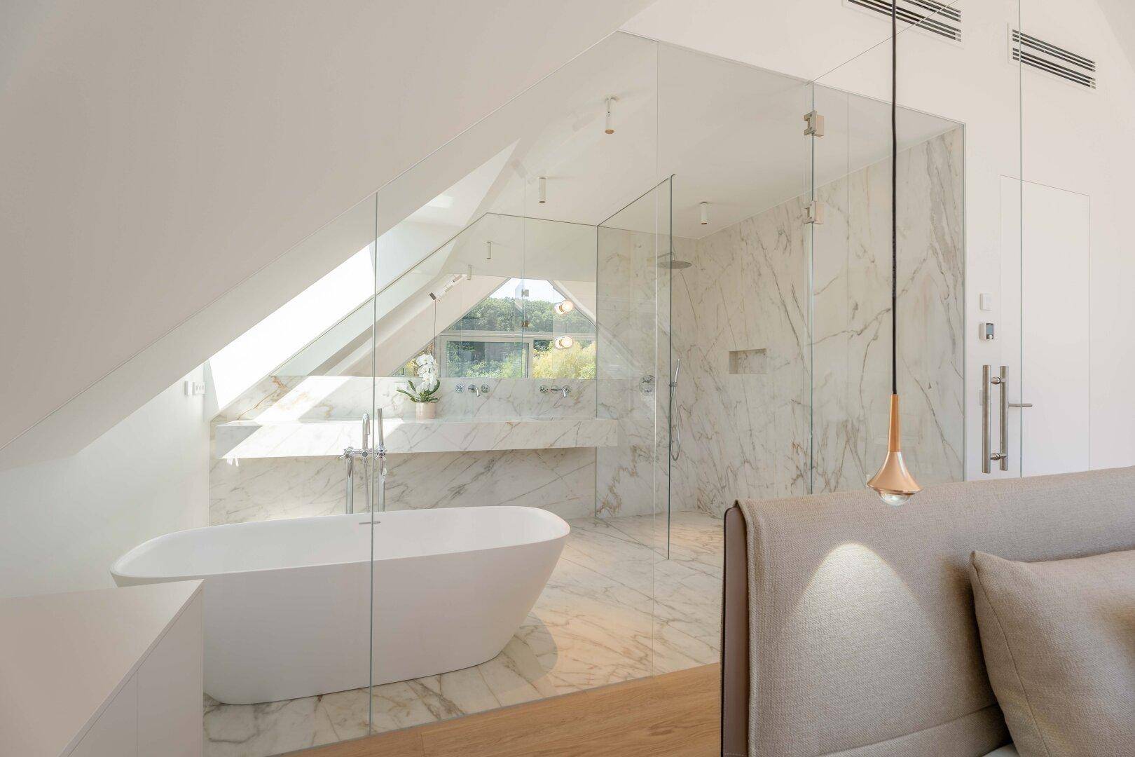 Luxuriöses Badezimmer mit freistehender Badewanne, begehbarer Dusche und Marmorfliesen im Dachgeschoss.