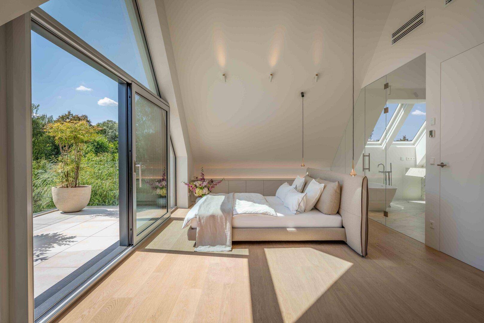 Helles Schlafzimmer mit direktem Zugang zur Terrasse und einem offenen Badezimmerbereich.