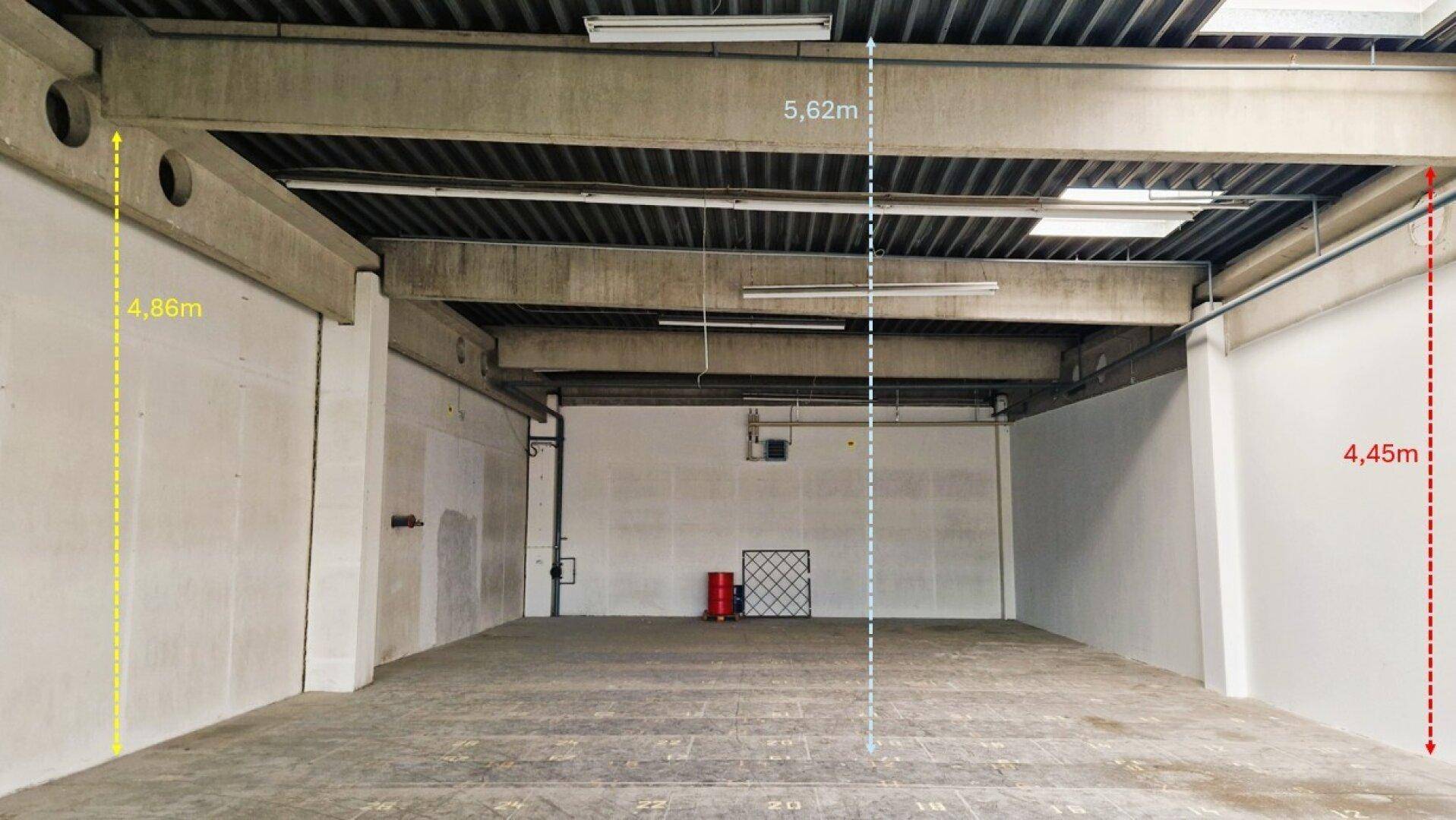 Großer, leerer Industrieraum mit hohen Decken, sichtbaren Betonbalken und robustem Betonboden.