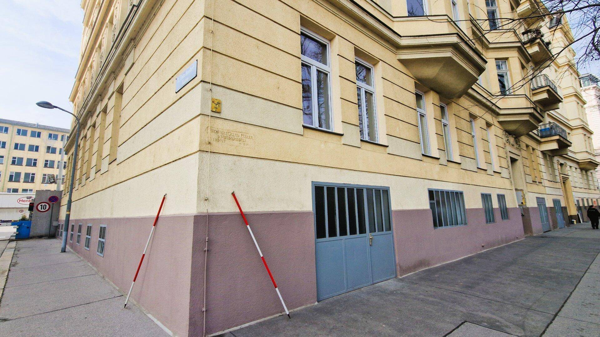 Historisches Gebäude mit einer gelben Fassade und einem großen Garagentor auf Straßenniveau in der Stadt.