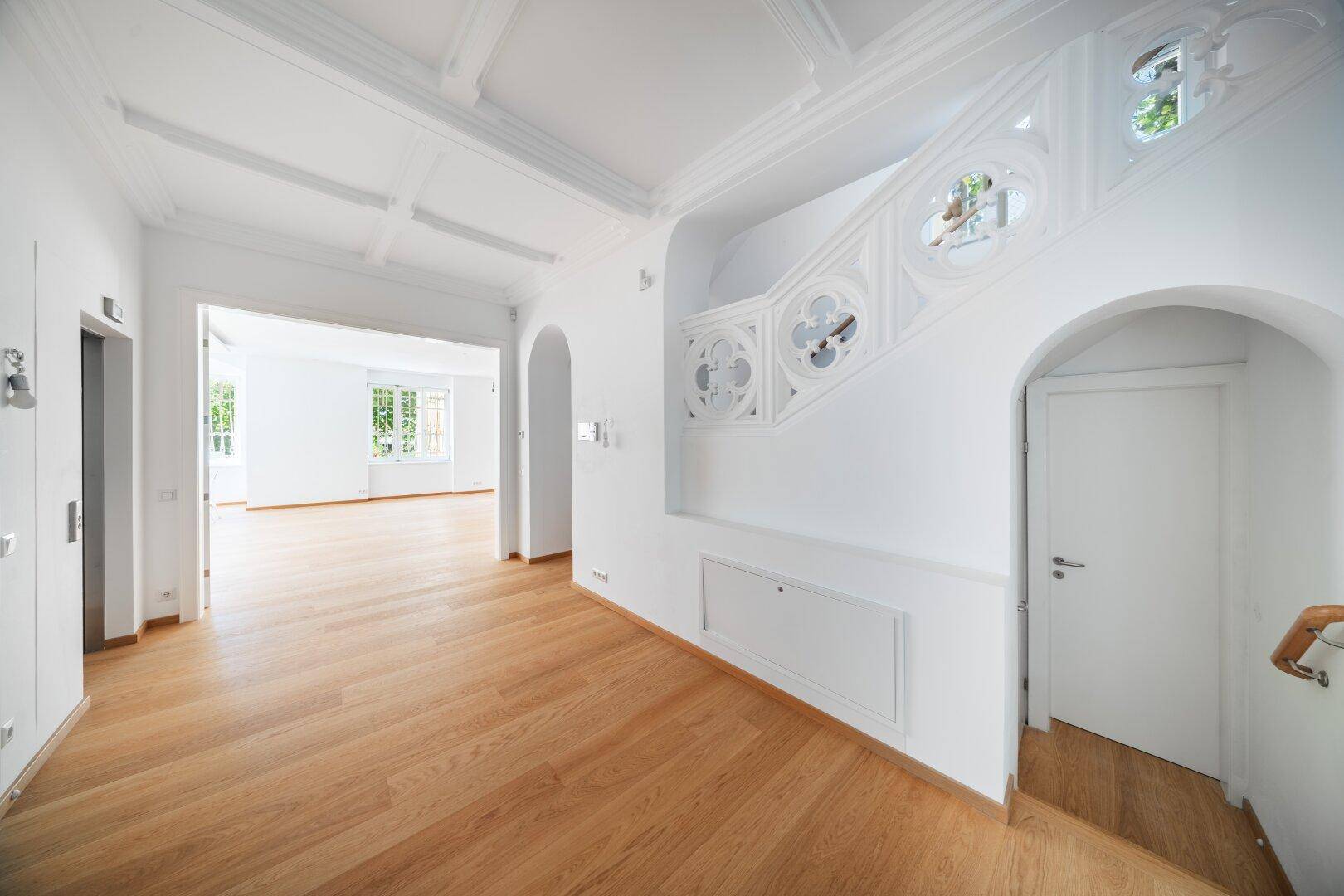Eleganter Flur mit Eichenparkett und einer kunstvoll gestalteten Treppe.