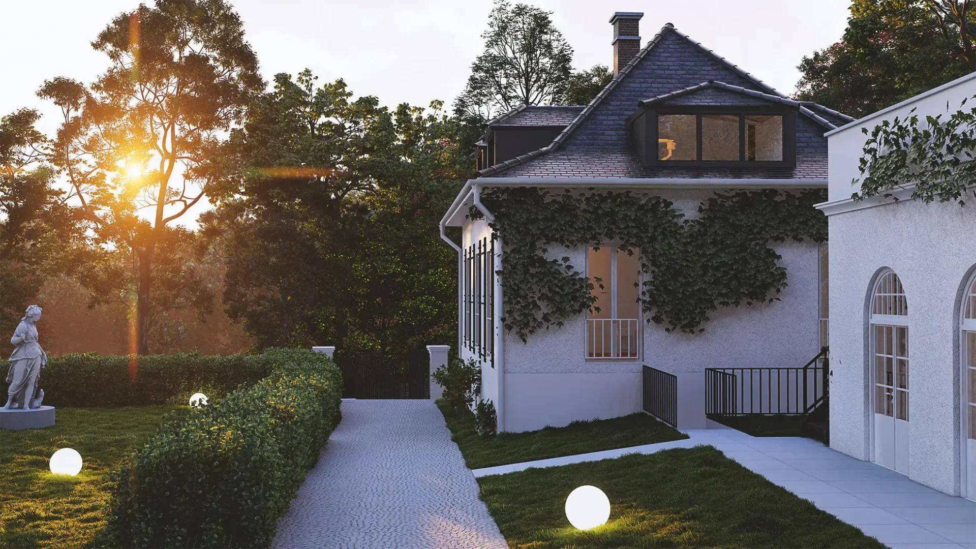 Seitenansicht der Villa mit gepflegtem Gartenbereich, Hecken und dekorativer Außenbeleuchtung bei Sonnenuntergang.