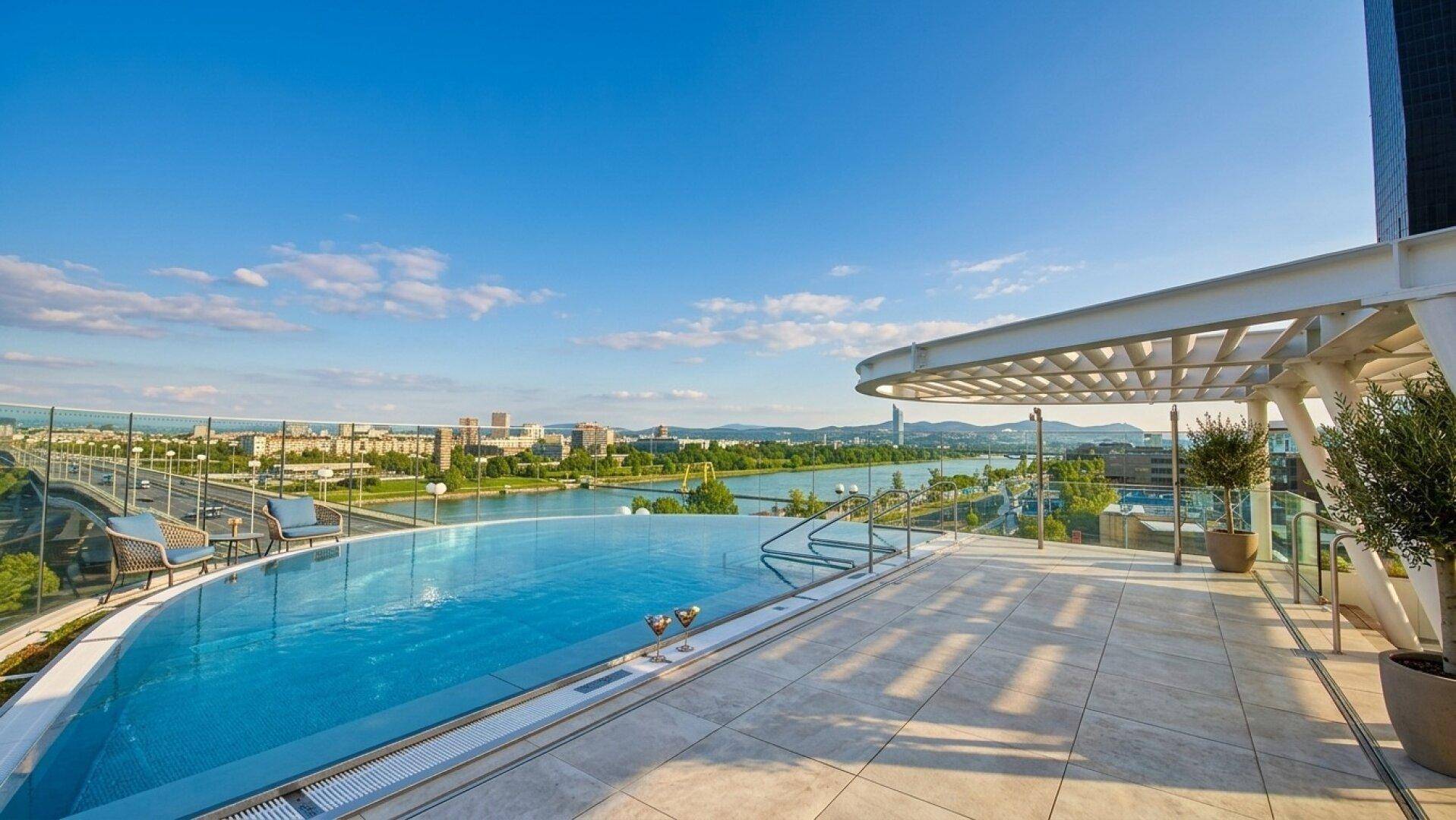 Exklusiver Infinity-Pool auf der Dachterrasse mit atemberaubendem Stadt- und Flussblick.