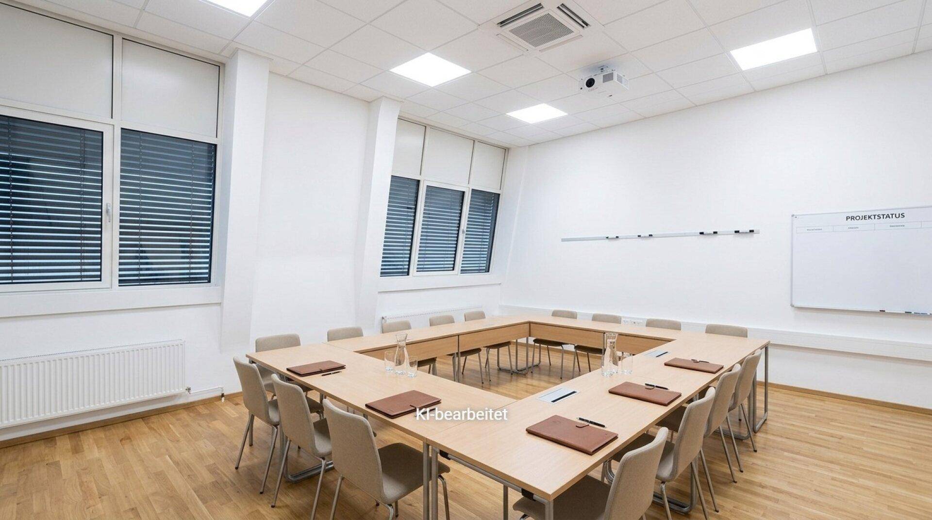 Großer Konferenzraum mit U-förmiger Tischordnung, Holzboden und Deckenbeleuchtung.