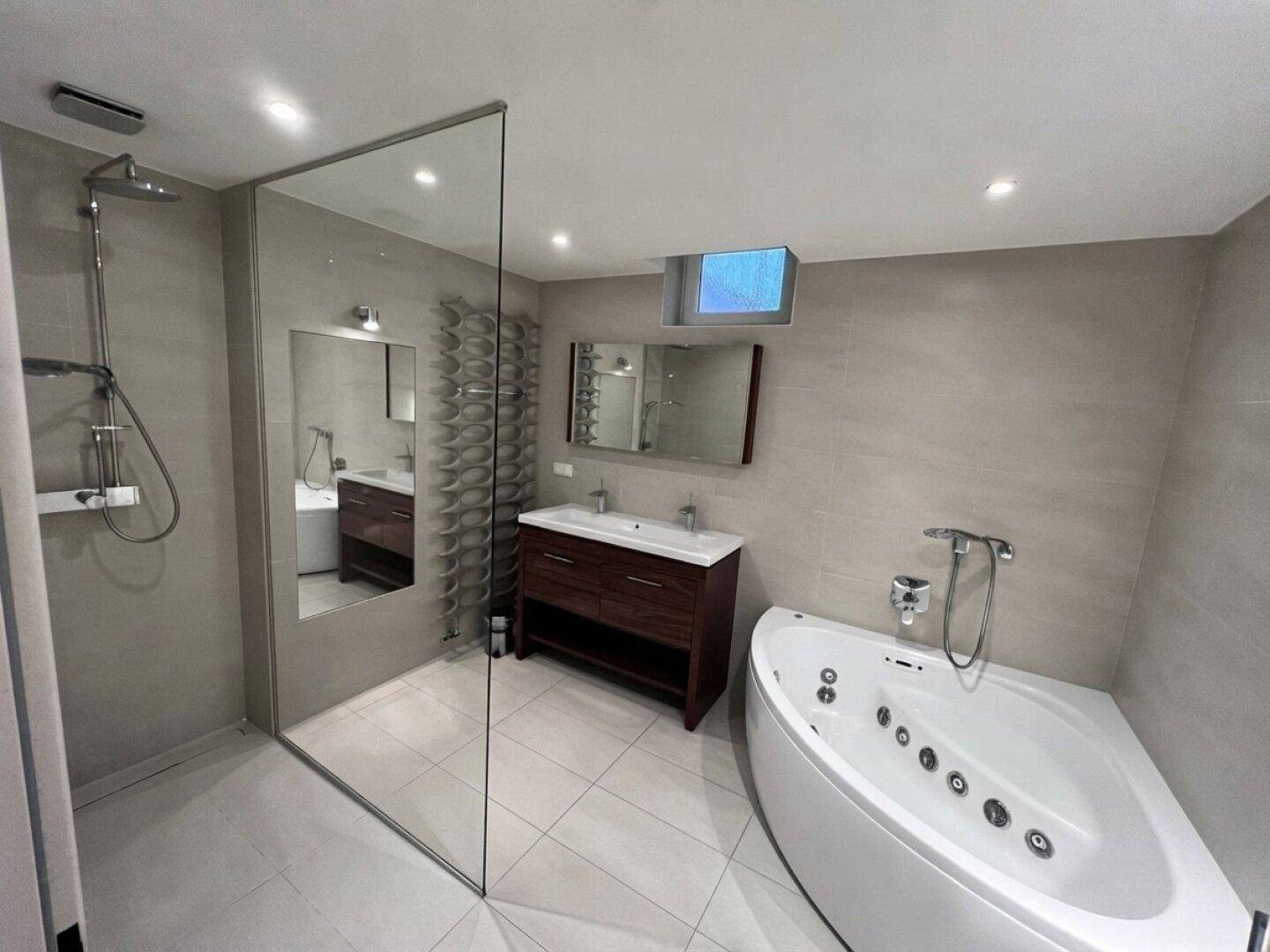 Modernes Badezimmer mit begehbarer Dusche, Eck-Whirlpool und Doppelwaschbecken.