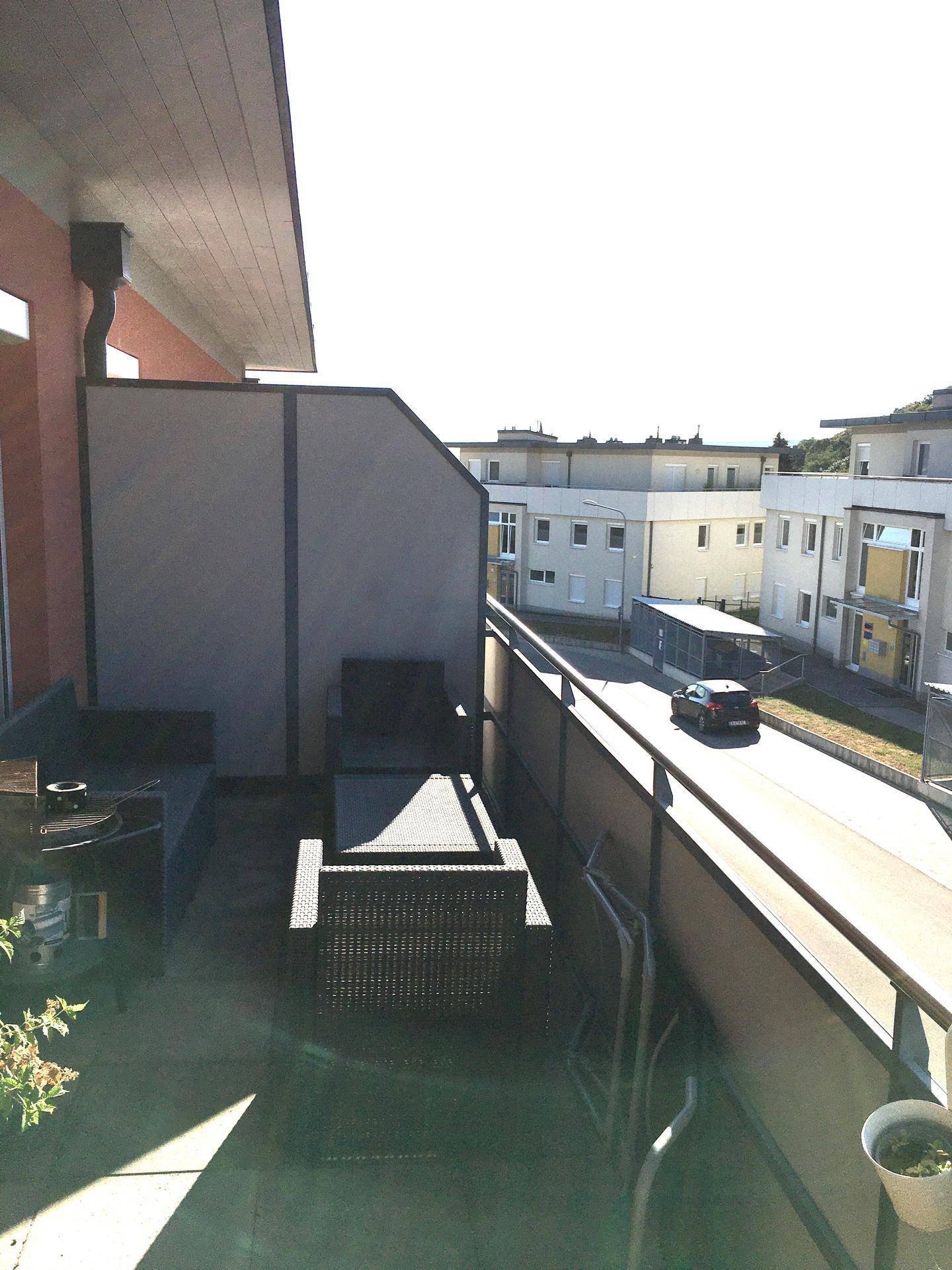 Möblierter Balkon mit Sitzgelegenheiten und Blick auf die umliegende Wohngegend.
