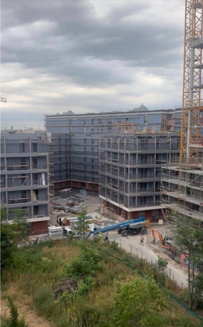 Blick auf eine Neubausiedlung mit mehreren Gebäuden, die sich noch im Bau befinden.