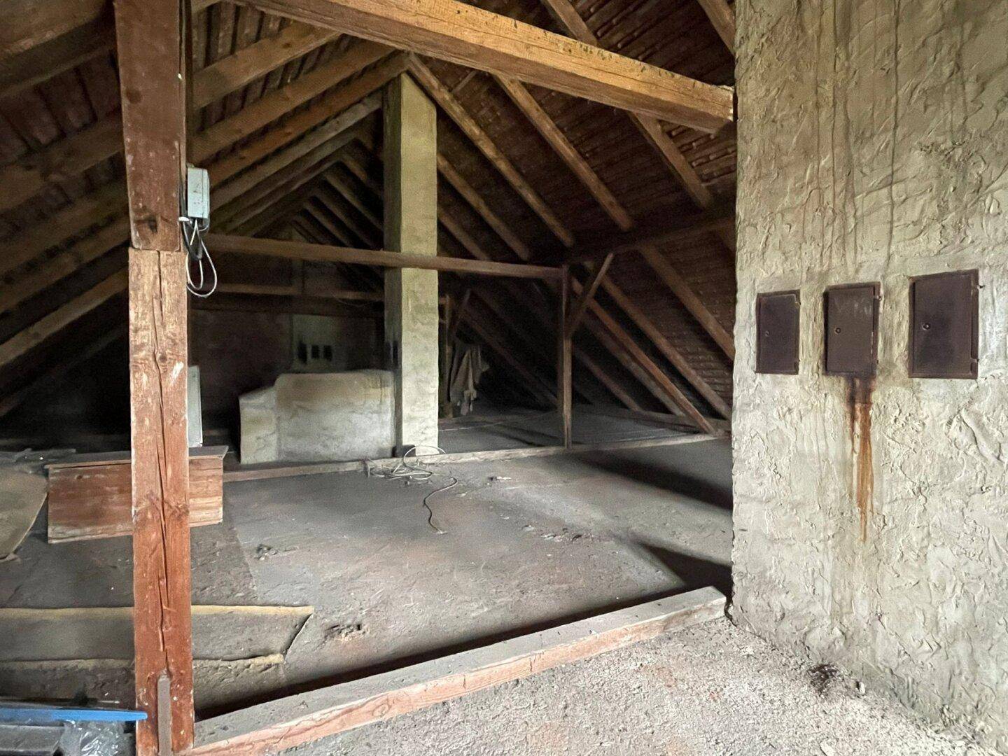 Geräumiger Dachboden mit Holzdachstuhl und unfertigen Wänden, der auf einen Ausbau wartet.