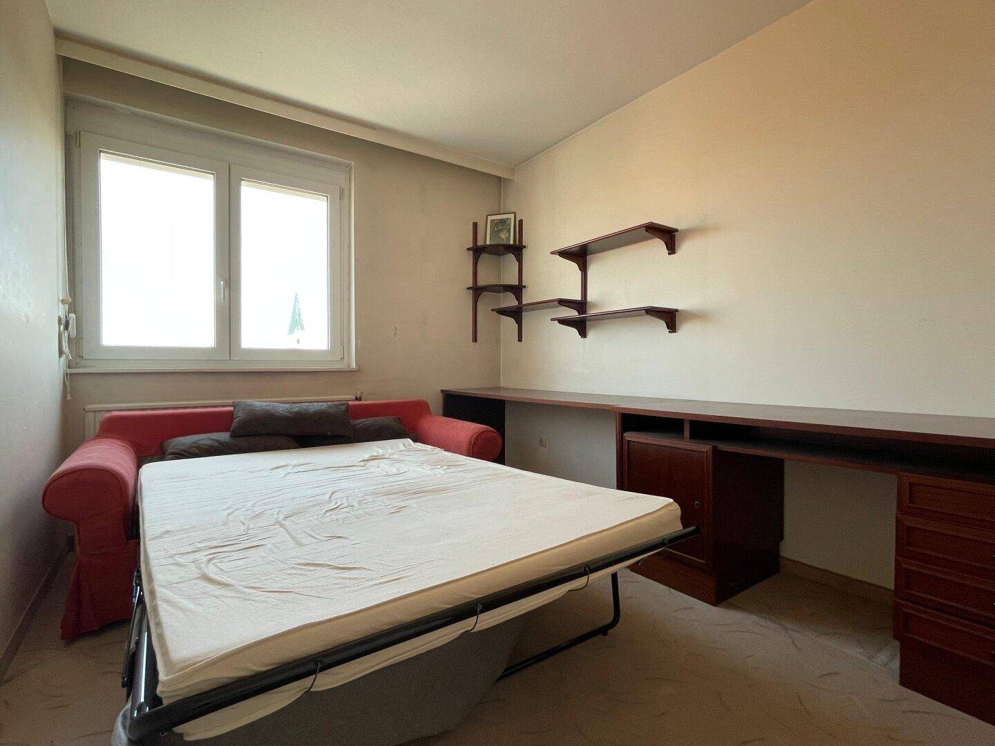 Vielseitiges Zimmer mit Schlafsofa und Schreibtischbereich, ideal als Gästezimmer oder Büro.