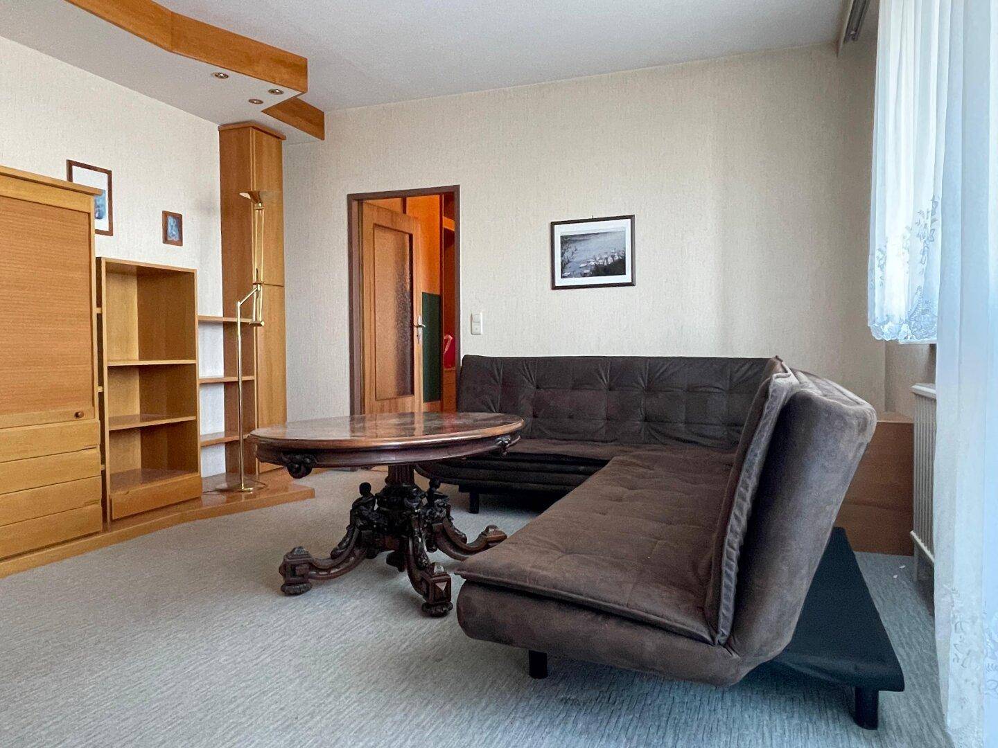 Helles Wohnzimmer mit Teppichboden und bequemen Sitzgelegenheiten, ideal für gemütliche Abende.