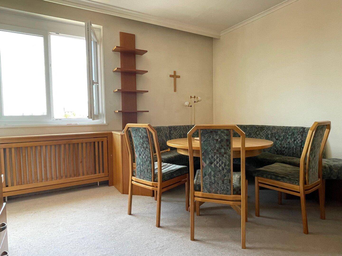 Gemütlicher Essbereich mit rundem Holztisch und Eckbank, perfekt für Familienmahlzeiten.