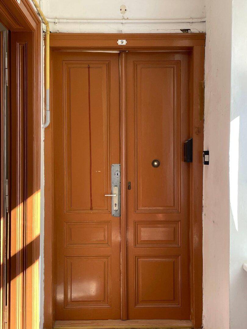 Detailaufnahme einer braunen Holztür mit der Nummer 9.