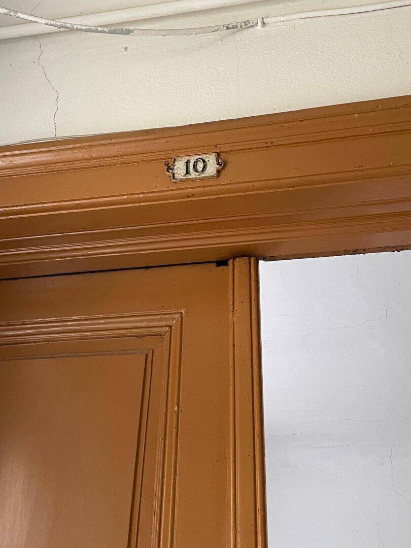 Detailaufnahme einer braunen Holztür mit der Nummer 10.