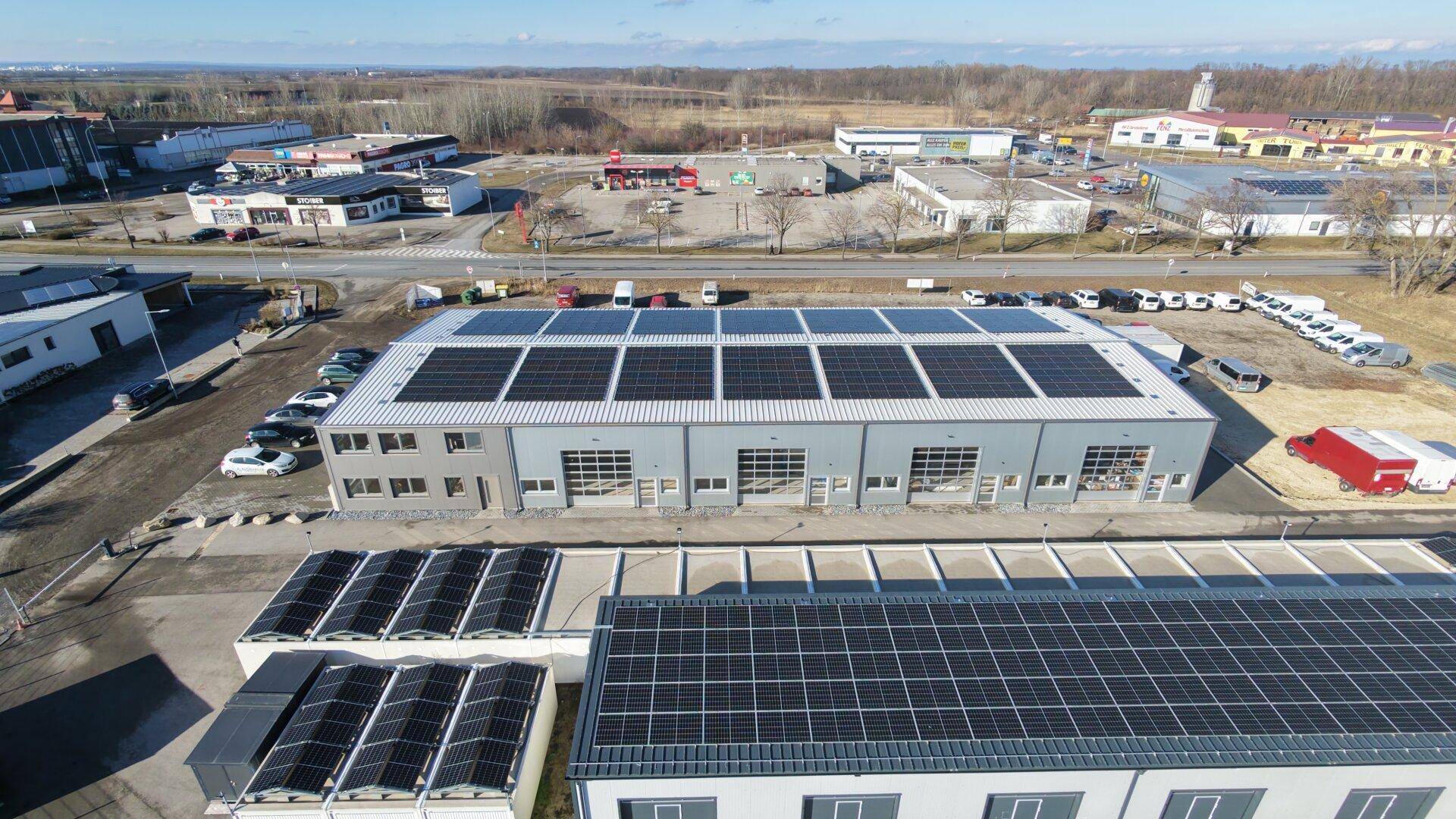 Nahaufnahme der Solarpaneele auf den Dächern des Gewerbegebäudes und der angrenzenden Strukturen.