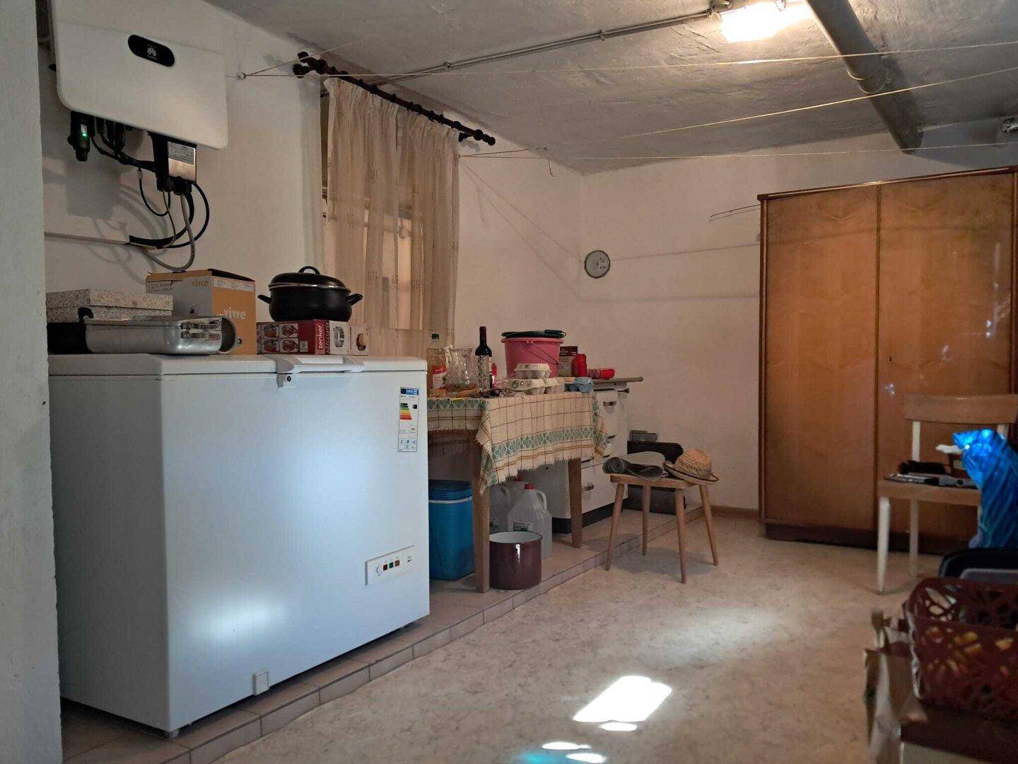 Kellerraum mit Gefriertruhe, Lagerfläche und Photovoltaik-Wechselrichter an der Wand, sehr praktisch.