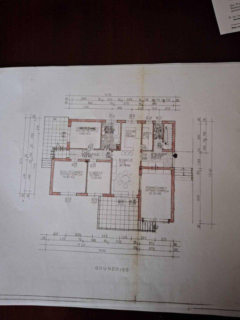 Grundriss des Erdgeschosses mit Zimmeraufteilung, Balkon und Terrasse, inklusive Bemaßungen.