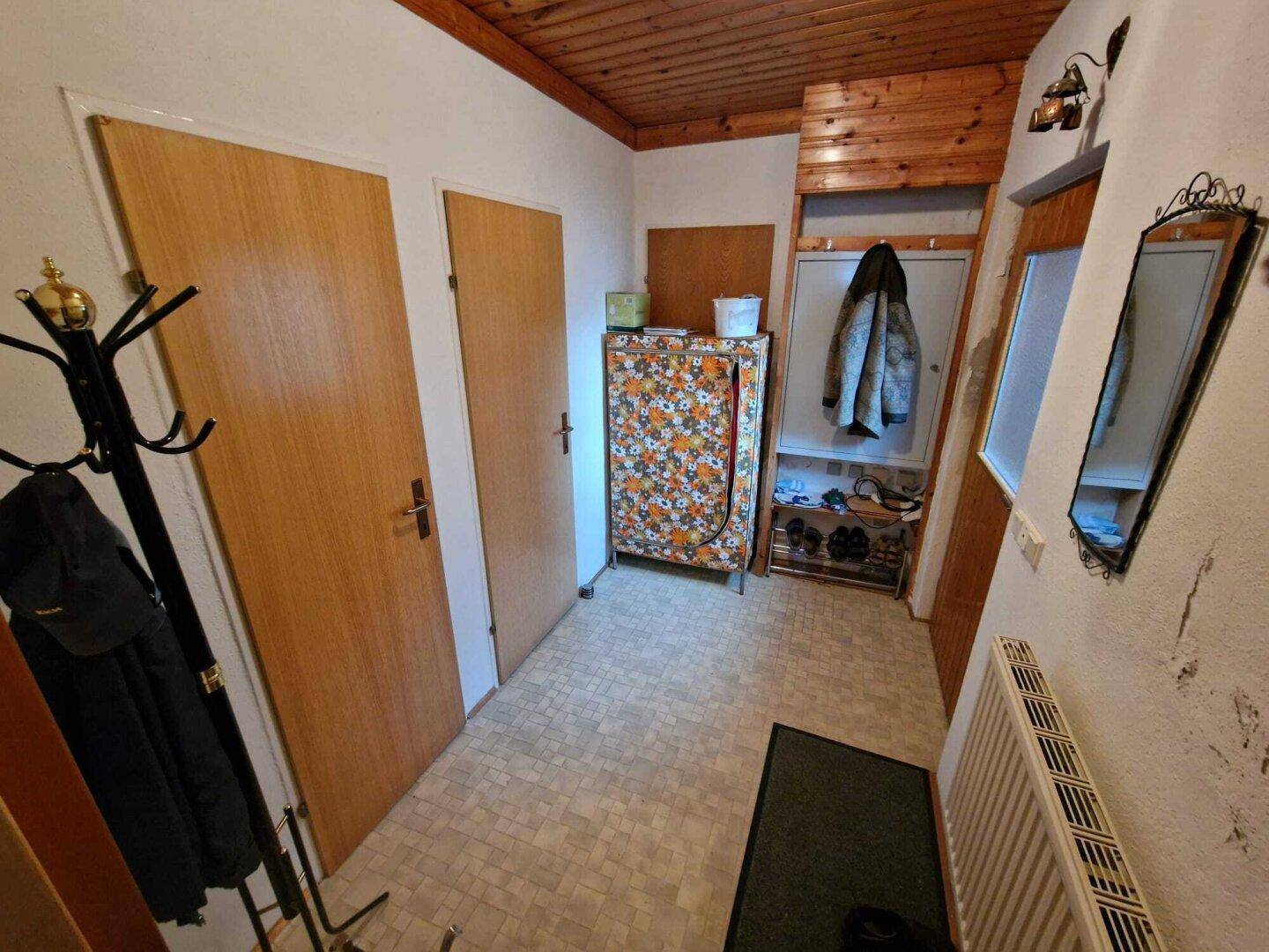 Gemütlicher Eingangsbereich mit Holzdecke, gemustertem Vinylboden und traditioneller Einrichtung.