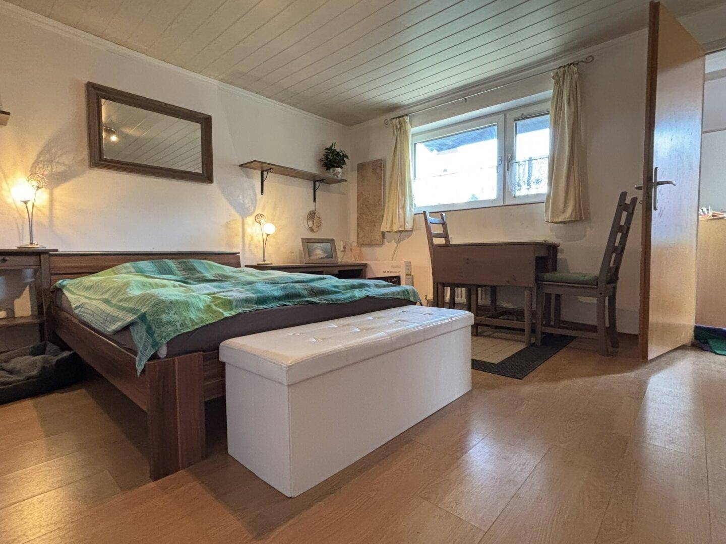 Gemütliches Schlafzimmer mit Holzbett, Nachttischen und einem großen Kleiderschrank.