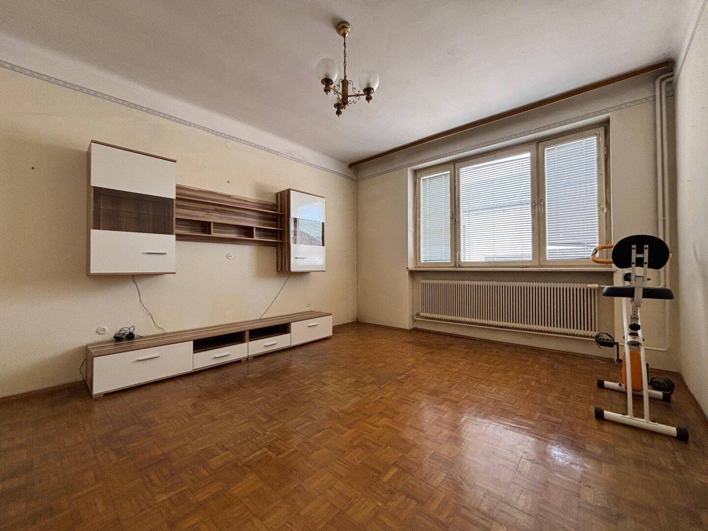 Ein Wohnzimmer mit Parkettboden und einer modernen Wandregal-Einheit.