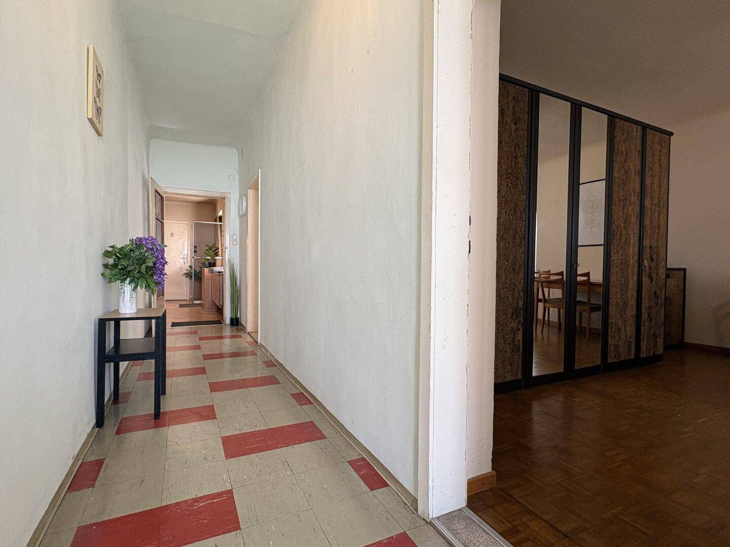Langer Flur mit gemusterten Fliesen und Zugang zu verschiedenen Räumen im Haus.