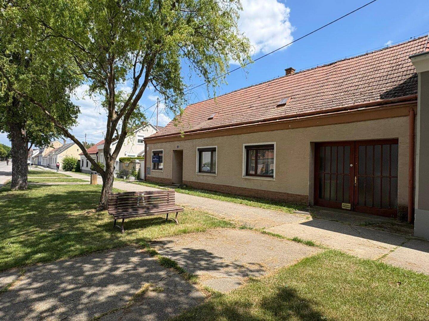 Einfaches Gebäude mit traditioneller Fassade und Ziegeldach, gelegen an einer ruhigen Straße.