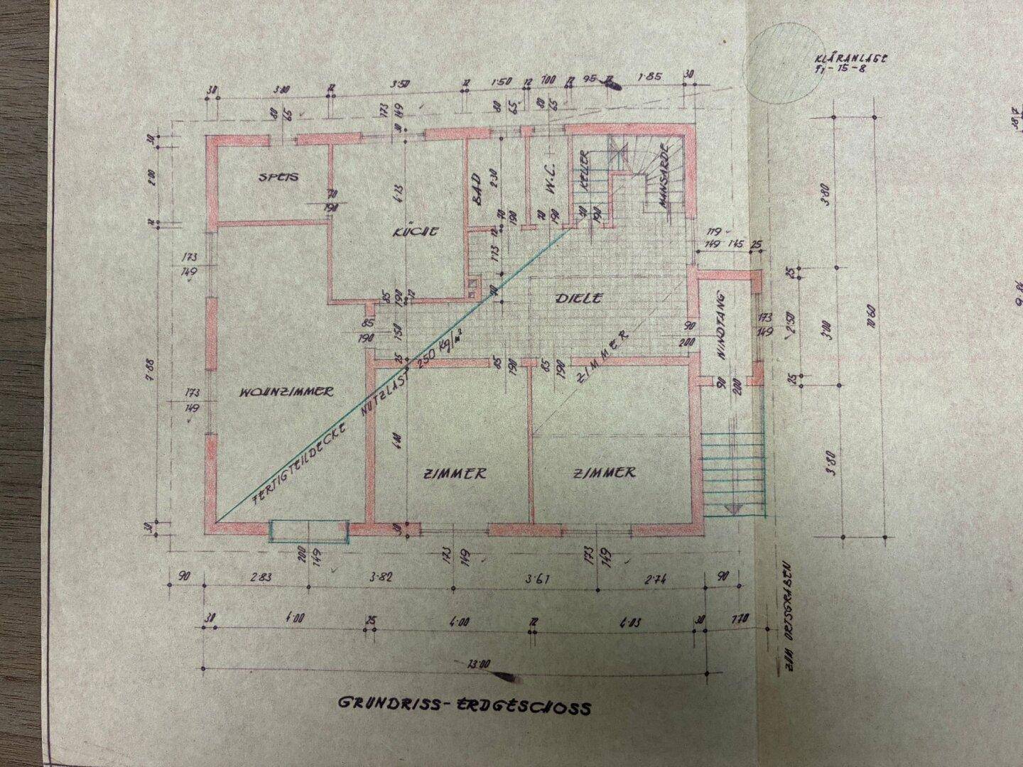 Grundriss des Erdgeschosses mit Wohnzimmer, Küche, Bad und mehreren Zimmern in traditioneller Aufteilung.