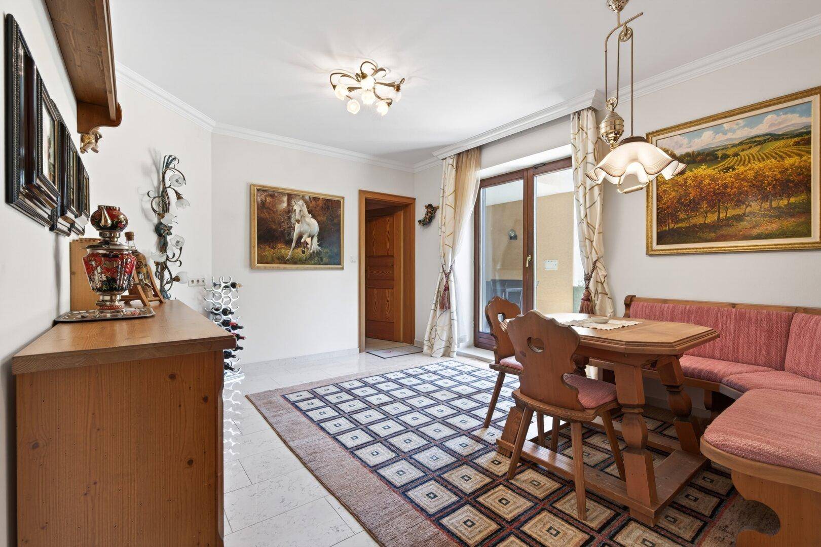 Gemütlicher Essbereich im Landhausstil mit Holztisch, Eckbank und Zugang zur Terrasse.