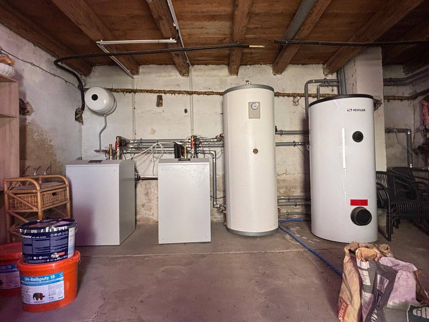 Technikraum im Keller mit Heizungsanlage und Warmwasserspeichern.