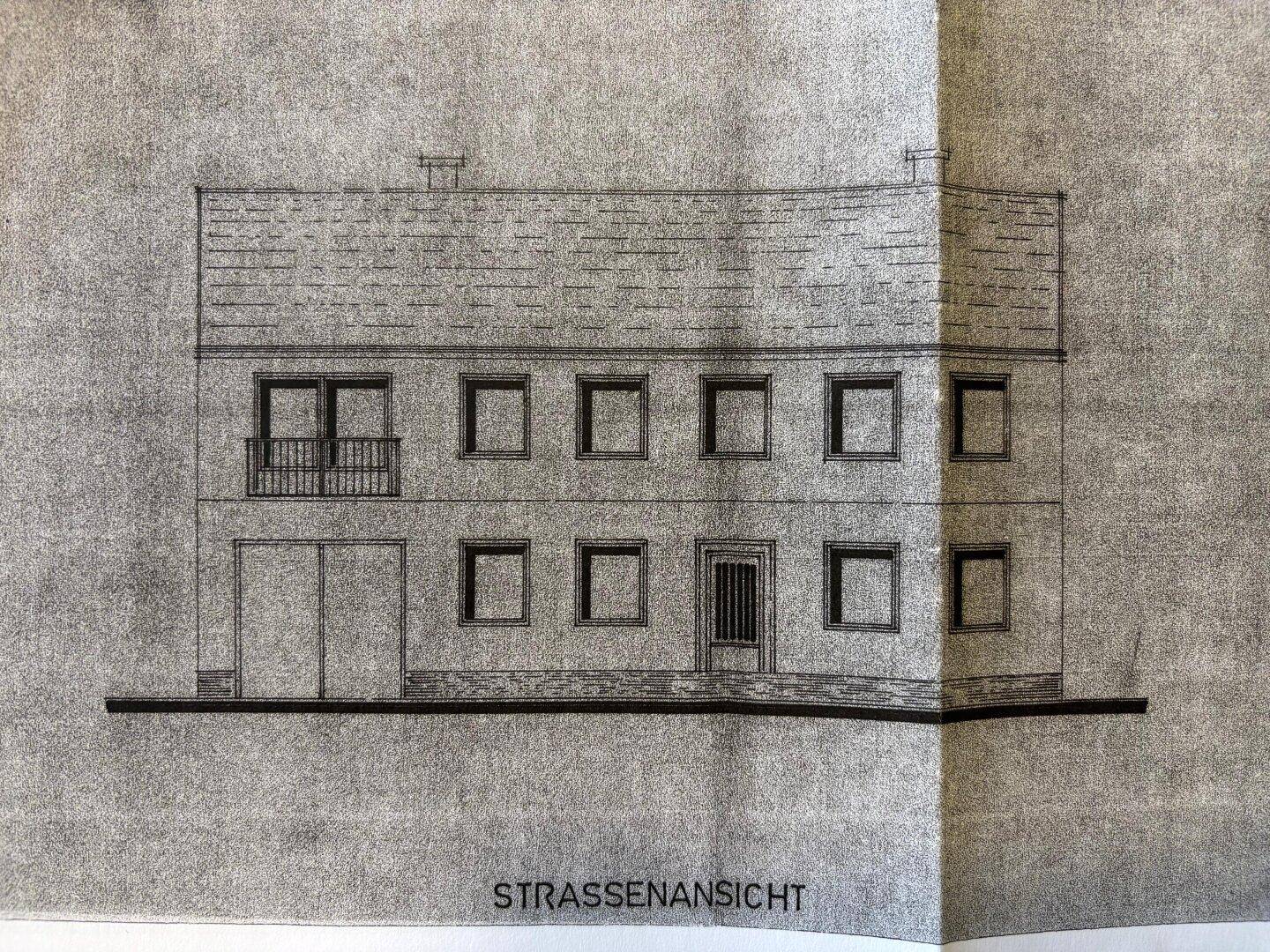 Architektonische Zeichnung der Straßenansicht des Gebäudes mit Balkon und Garage.