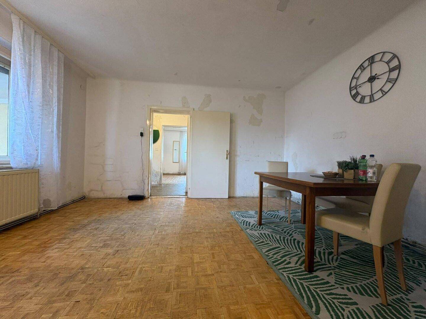 Essbereich mit Holzboden, Esstisch und Blick in einen weiteren Raum.
