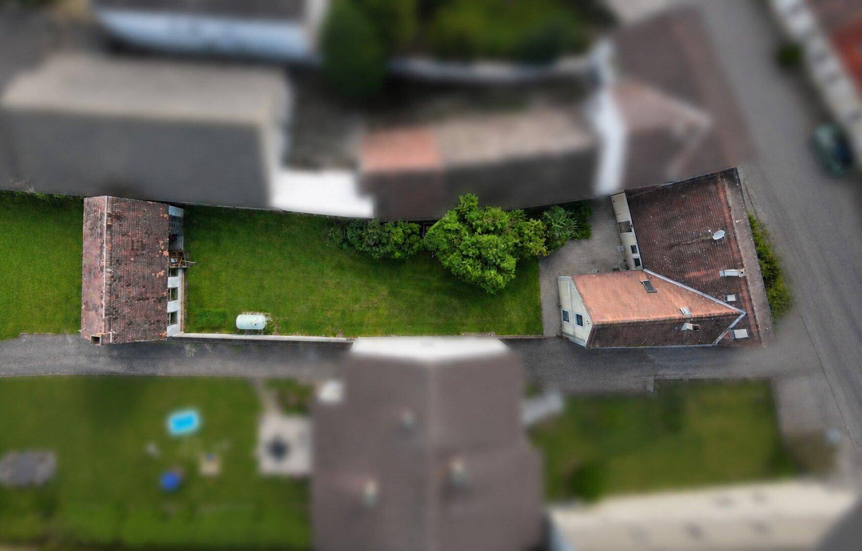 Luftaufnahme des Grundstücks mit Gebäuden und großem Gartenbereich.