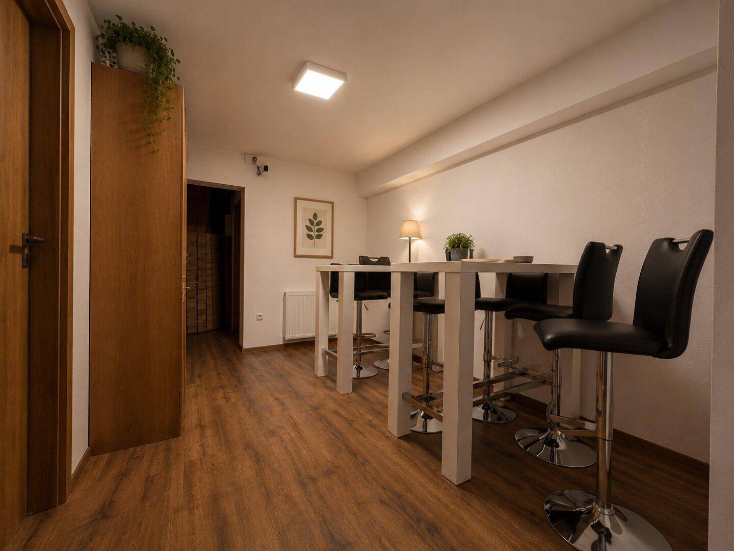 Essbereich mit Bartisch und Hockern, ideal für gesellige Runden.