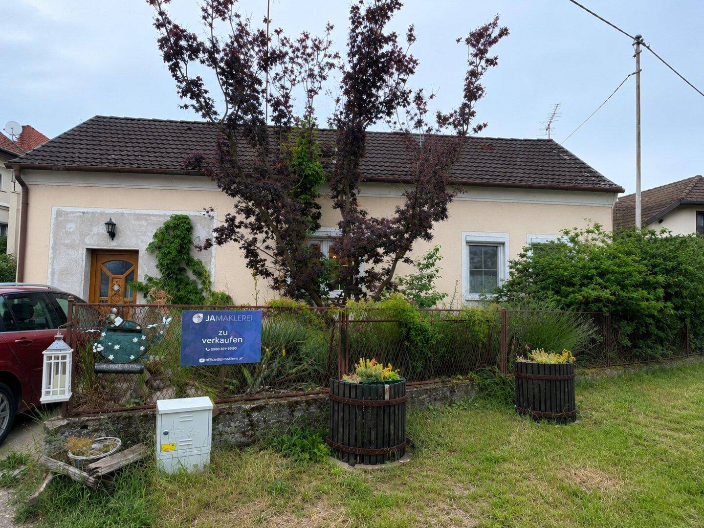 Gepflegtes Einfamilienhaus mit Satteldach und Vorgarten, umgeben von Grünflächen.