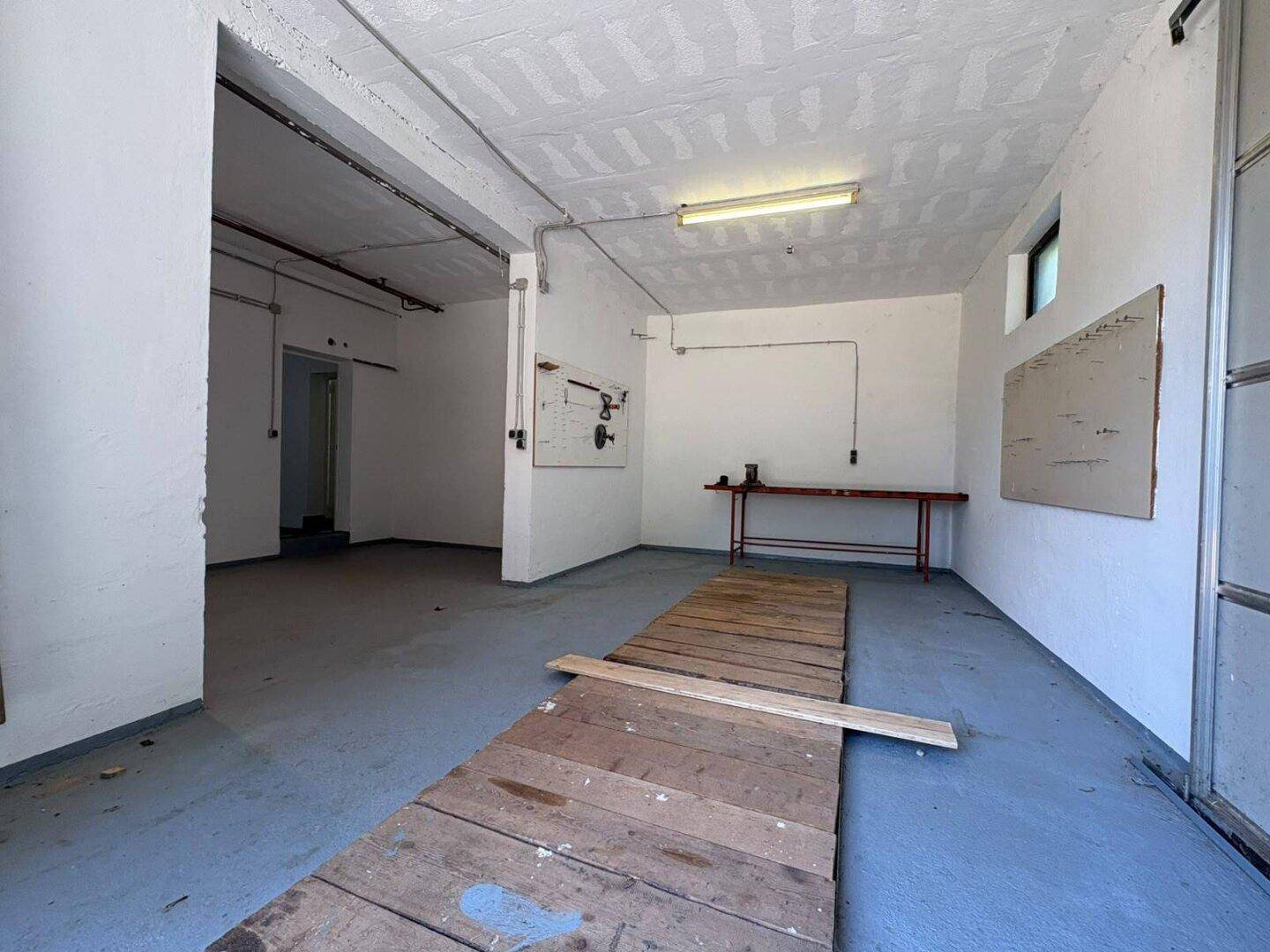 Geräumiger Kellerraum, nutzbar als Werkstatt oder Garage, mit Rampe und Zugang nach draußen.