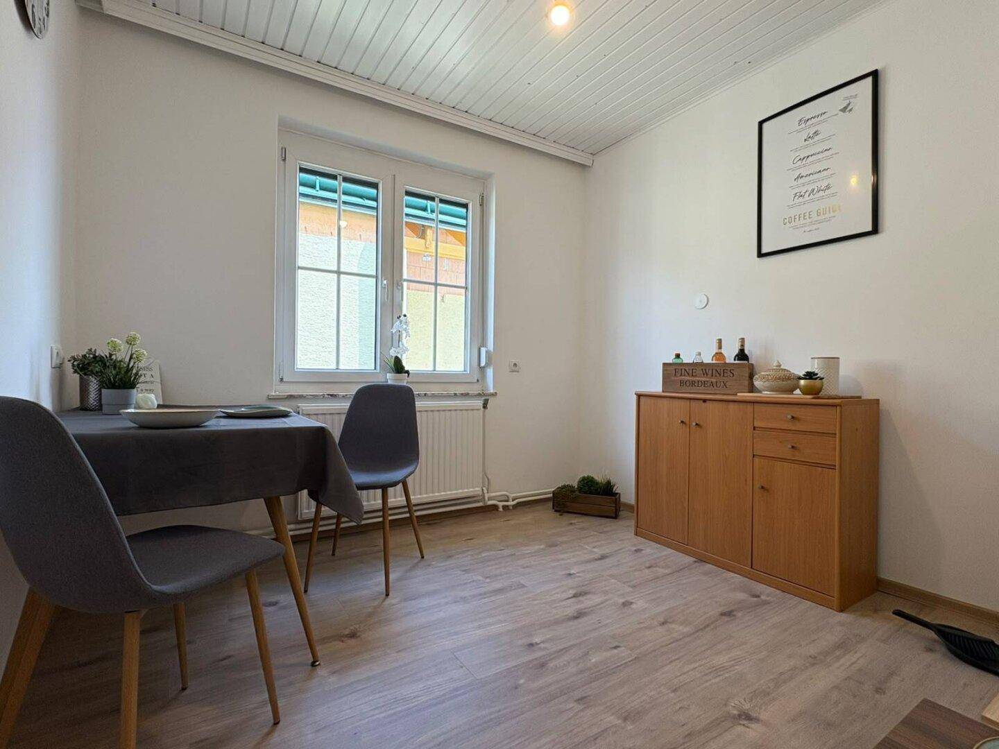 Heller Essbereich mit Laminatboden, Esstisch und Stühlen, ideal für gemeinsame Mahlzeiten.