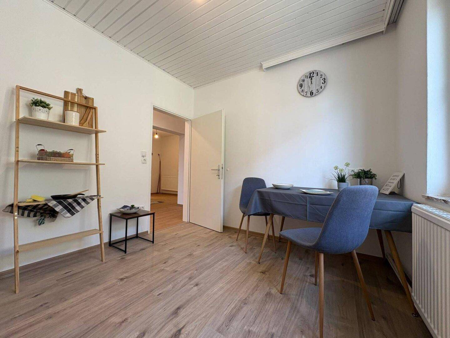 Esszimmer mit Laminatboden, modernem Regal und einem Esstisch für gesellige Runden.