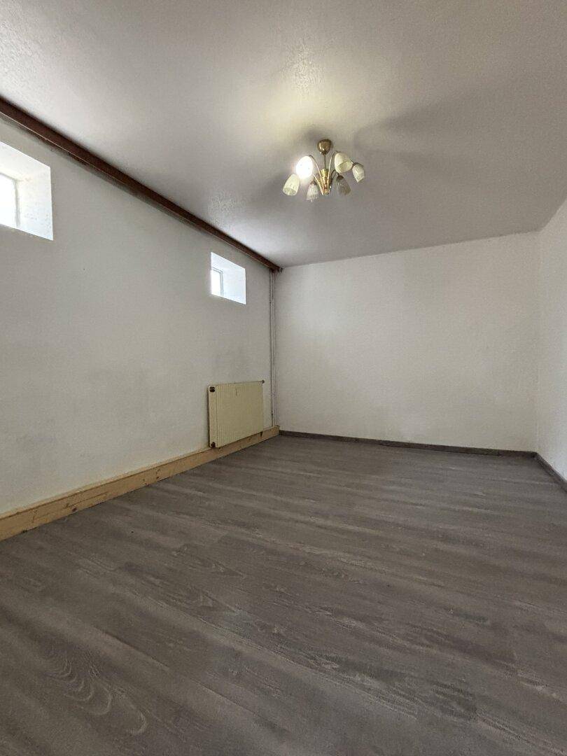 Heller Raum mit neuem Laminatboden und kleinen Fenstern, vielseitig nutzbar.