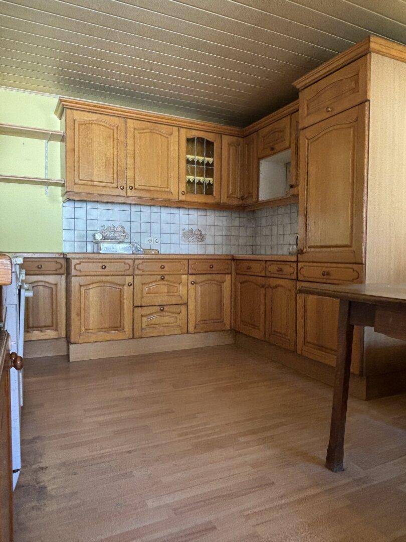 Traditionelle Holzküche mit Einbauschränken, Fliesenrückwand und Holzdecke.
