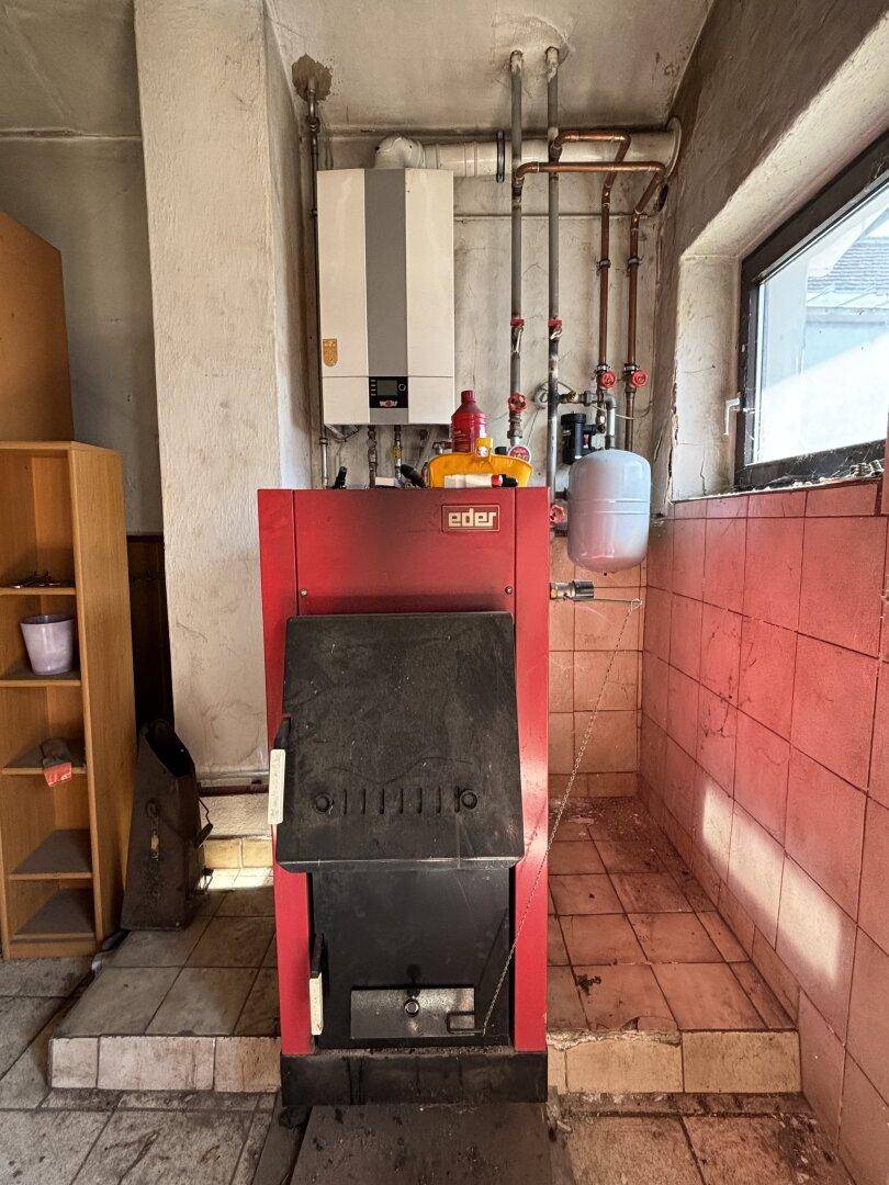 Heizungsraum mit einem modernen Heizkessel und sichtbaren Rohrleitungen.