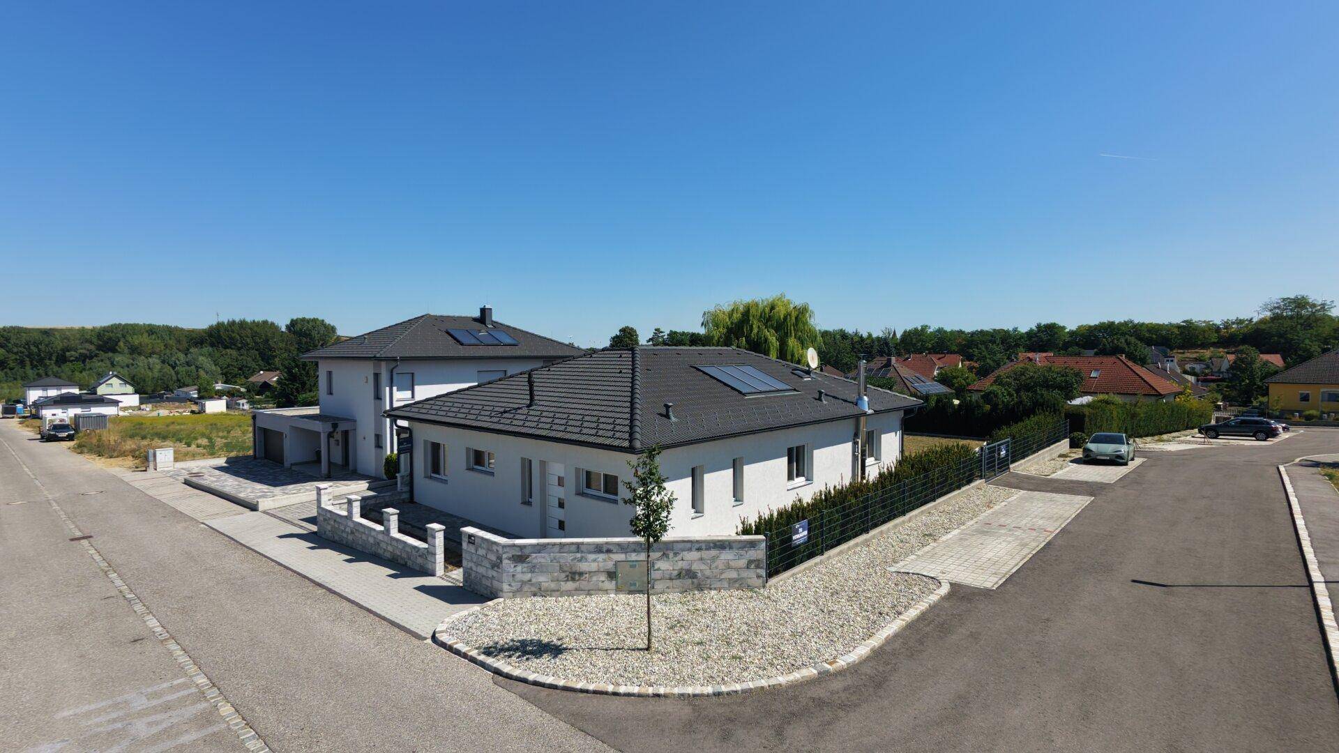 Luftaufnahme des Einfamilienhauses mit gepflegtem Vorgarten und ländlicher Umgebung.