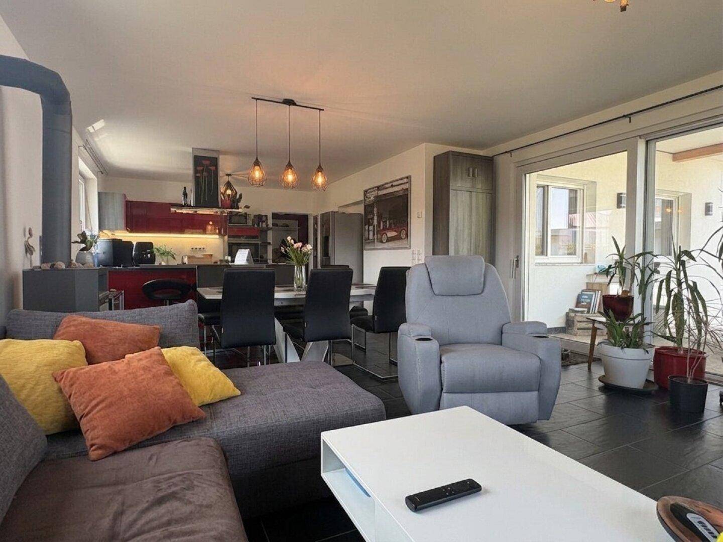 Gemütlicher Wohnbereich mit Sofa, Esstisch und Zugang zur Terrasse.